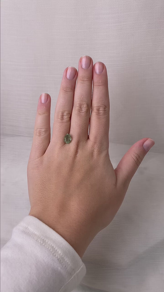 Video of teardrop shaped green stone on hand 